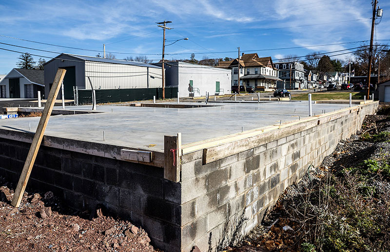 Concrete foundation of a construction site in Halifax, Dauphin County, with nearby homes and buildings