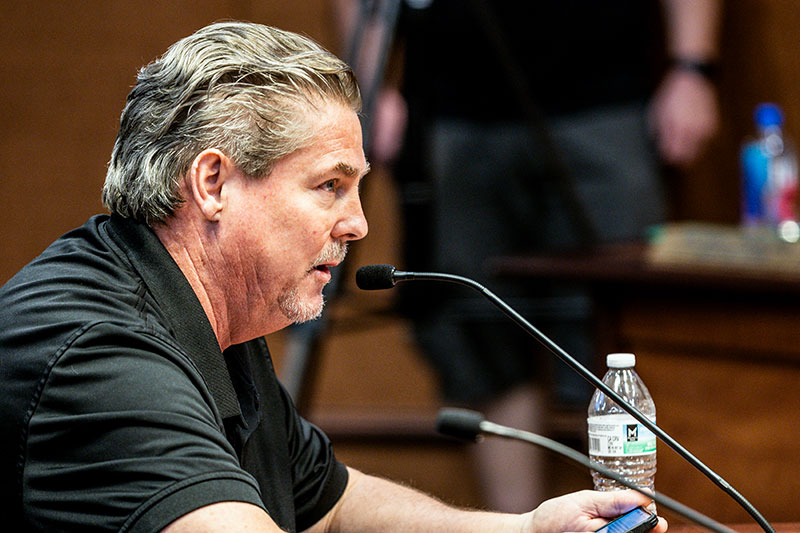 Tom Connolly speaking into a microphone at a public meeting in Dauphin County